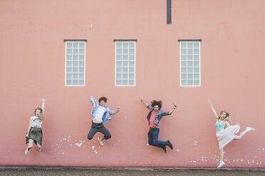 Freunde springen gegen rosa Wand Hintergrund - CUF22823