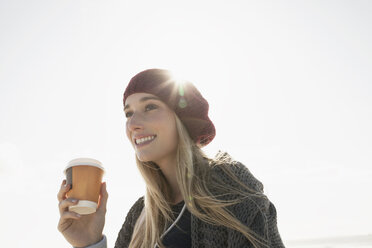Junge Frau hält eine Tasse Kaffee an einem kalten Tag - CUF22835