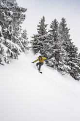 Mann fährt mit dem Snowboard einen steilen Berghang hinunter in Kranzegg, Bayern, Deutschland - CUF22845