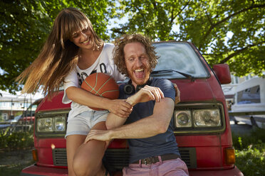 Junges Paar, das im Freien herumalbert, lachend, junge Frau hält Basketball - CUF22911