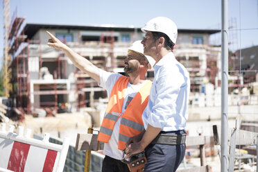 Bauarbeiter im Gespräch mit Mann auf Baustelle - MOEF01258