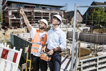 Bauarbeiter im Gespräch mit Mann auf Baustelle - MOEF01270