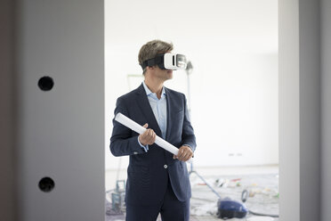 Mann im Anzug mit VR-Brille in einem im Bau befindlichen Gebäude - MOEF01279