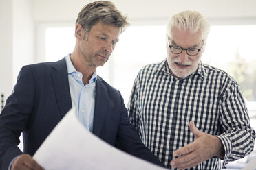 Man in suit and senior man looking at blueprint - MOEF01281