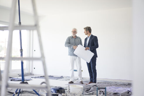 Man in suit and senior man talking on room under construction - MOEF01285