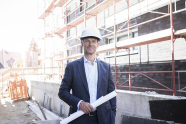 Portrait of confident architect wearing hard hat on construction site - MOEF01293