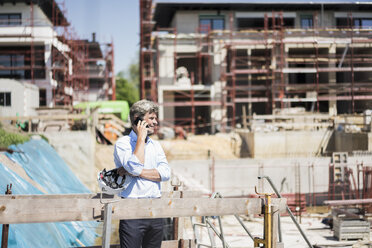 Mann mit Mobiltelefon auf einer Baustelle - MOEF01304