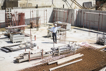 Man wearing hard hat on construction site looking around - MOEF01308
