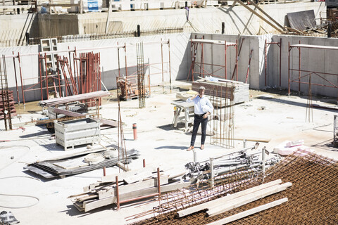 Mann mit Mobiltelefon auf einer Baustelle, lizenzfreies Stockfoto