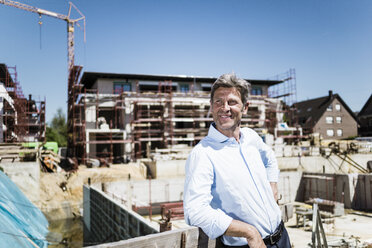 Smiling man on construction site looking around - MOEF01327