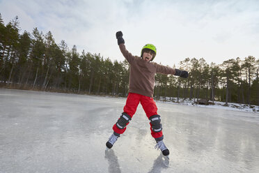 Junge balanciert beim Schlittschuhlaufen auf einem zugefrorenen See, Gavle, Schweden - CUF23015