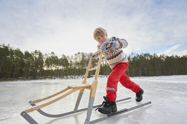 Junge schiebt Tretroller über einen zugefrorenen See, Gavle, Schweden - CUF23016