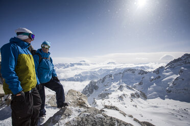 Zwei männliche Snowboarder blicken auf eine verschneite Landschaft, Trient, Schweizer Alpen, Schweiz - CUF23029