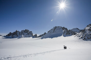 Four male snowboarders hiking across snow-covered landscape, Trient, Swiss Alps, Switzerland - CUF23030