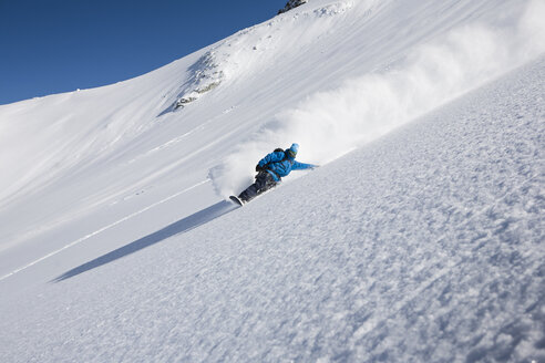 Männlicher Snowboarder rast einen steilen Berg hinunter, Trient, Schweizer Alpen, Schweiz - CUF23034