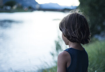 Rückansicht eines Jungen am Fluss, der wegschaut - CUF23058