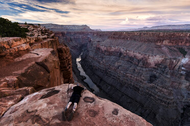 Man lying on rock, looking at view, Torroweap Overlook, Grand Canyon, Torroweap, Arizona, USA - CUF23067