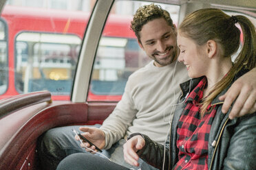 Young couple on front seat of double-decker, Kings Road, London, UK - CUF23079