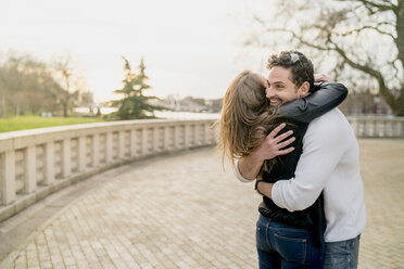 Young happy couple hugging in Battersea Park, London, UK - CUF23080