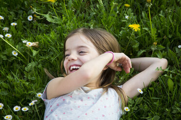 Porträt eines lachenden kleinen Mädchens, das auf einer Wiese liegt - LVF07032
