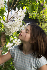 Porträt eines Mädchens, das an der Blüte des weißen Flieders riecht - LVF07033