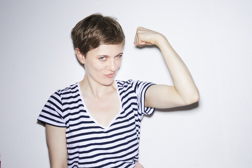 Portrait of blond woman, short hair, showing muscles - PNEF00677