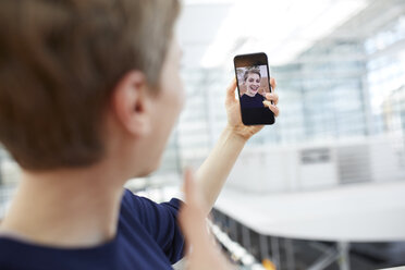 Porträt einer blonden Geschäftsfrau, die ein Selfie macht - PNEF00705