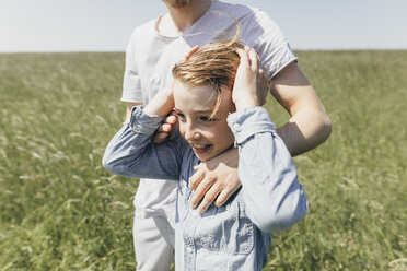 Happy boy and young man in a field - KMKF00303