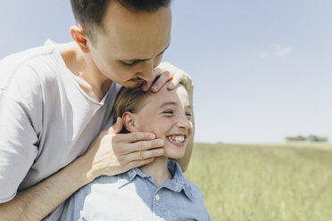 Happy boy and young man in a field - KMKF00304