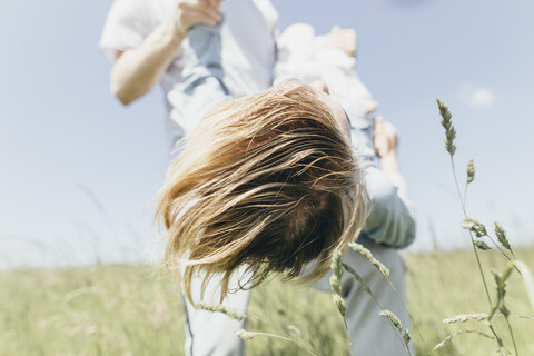 Man carrying happy boy in a field stock photo