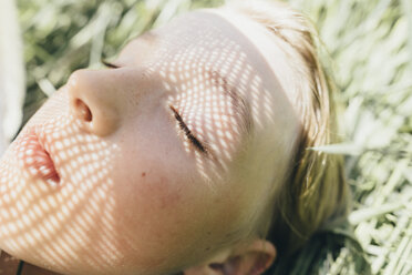 Close-up of boy lying in field - KMKF00313