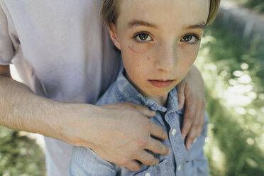 Portrait of boy being embraced by a man - KMKF00323