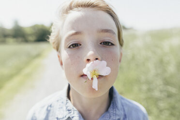 Porträt eines Jungen mit einer Blüte im Mund - KMKF00338