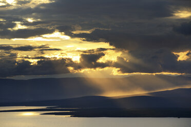 Silhouettierte Berge und Sonnenstrahlen über dem Imandra-See, Khibiny-Gebirge, Kola-Halbinsel, Russland - CUF23110