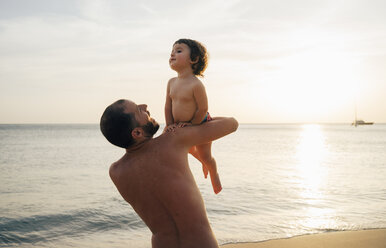 Thailand, Koh Lanta, Vater spielt mit seiner kleinen Tochter am Strand bei Sonnenuntergang - GEMF02055