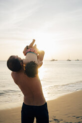 Thailand, Koh Lanta, father playing with his little daughter on the beach at sunset - GEMF02057