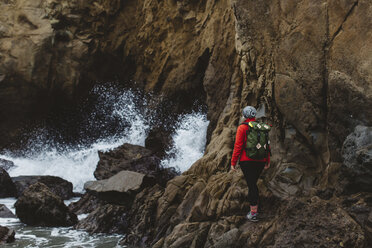 Wanderer klettert über Felsen, Big Sur, Kalifornien, USA - ISF08819