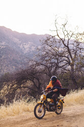 Mann fährt Motorrad, eingewickelt in eine Decke, Sequoia National Park, Kalifornien, USA - ISF08828
