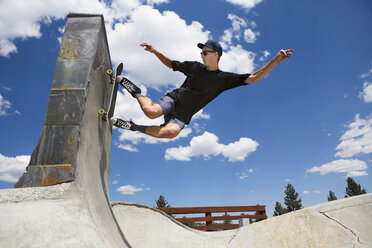 Junger Mann beim Skateboardfahren auf der Rampe eines Skateparks, Mammoth Lakes, Kalifornien, USA - ISF08831