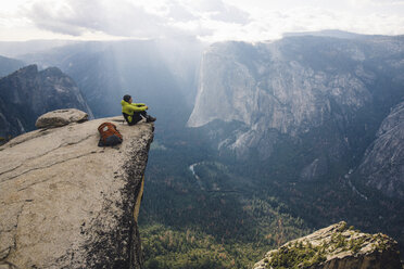 Man sitting at top of mountain, overlooking Yosemite National Park, California, USA - ISF08833