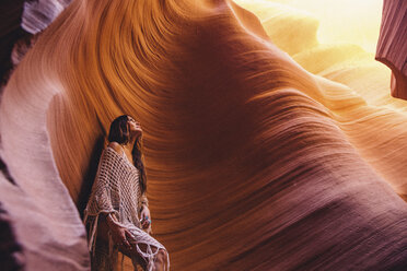 Frau, die in einer Höhle in das Sonnenlicht blickt, Antelope Canyon, Page, Arizona, USA - ISF08844