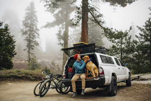 Mann und Hund sitzen auf der Heckklappe eines Geländewagens, Sequoia National Park, Kalifornien, USA - ISF08850