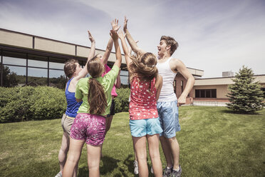 Jugendliche Gymnasiasten, die sich vor der Schule im Kreis abklatschen - ISF08853