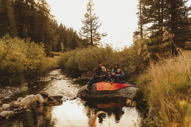 Familie sitzt auf einem Felsen neben einem Bach und angelt, Mineral King, Sequoia National Park, Kalifornien, USA - ISF08873