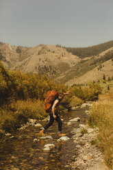 Mann mit Rucksack beim Überqueren eines Baches, Mineral King, Sequoia National Park, Kalifornien, USA - ISF08876