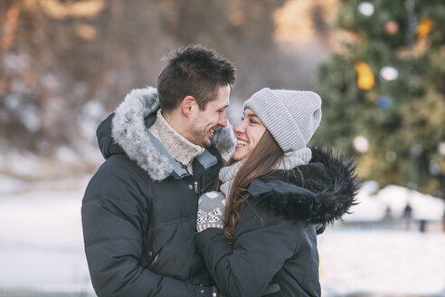 Lächelndes Paar in warmer Kleidung, das im Freien steht - FSIF03045