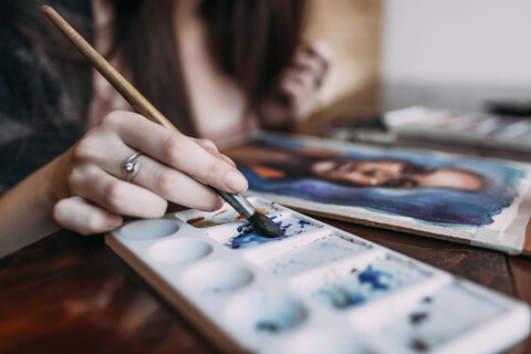 Nahaufnahme einer jungen Frau, die in einem Café malt, lizenzfreies Stockfoto