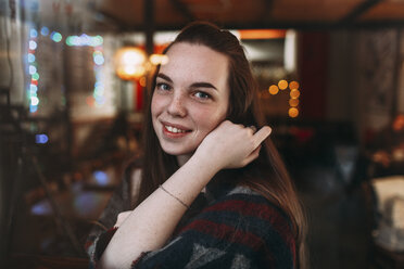 Porträt einer lächelnden schönen jungen Frau im Café - FSIF03049
