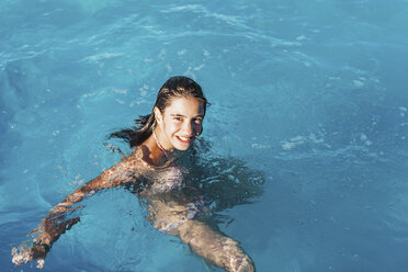 High angle portrait of smiling girl at swimming in pool - FSIF03108