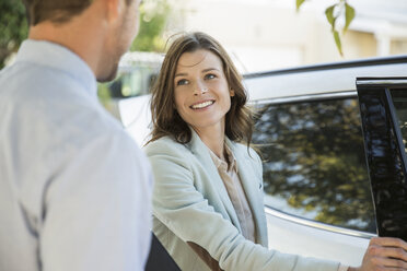 Young businesswoman and boyfriend on street before leaving in car - ISF08893